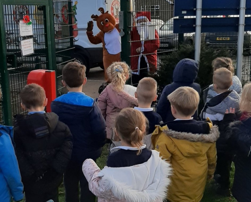 Rudy the reindeer waving to school children
