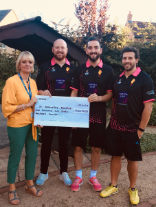 Three men and a blonde woman holding large presentation cheque in support of St Barnabas Hospice.