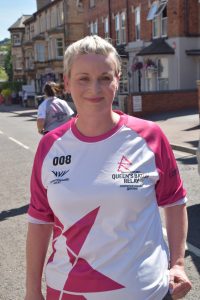 Blonde woman in white and pink T-shirt, smiling