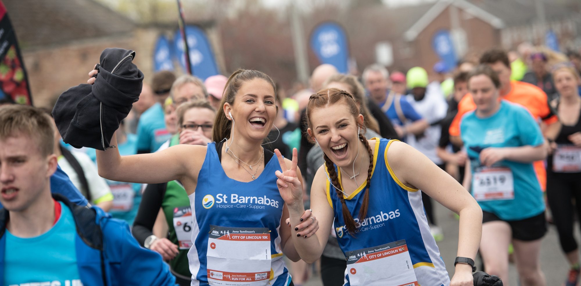 Two woman, wearing St Barnabas running shirts, taking part inthe city of Lincoln 10k in 2019