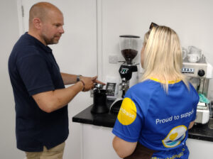 Man and blonde woman at a coffee machine