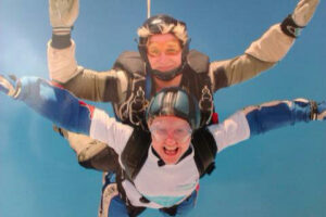 Two people clipped together skydiving