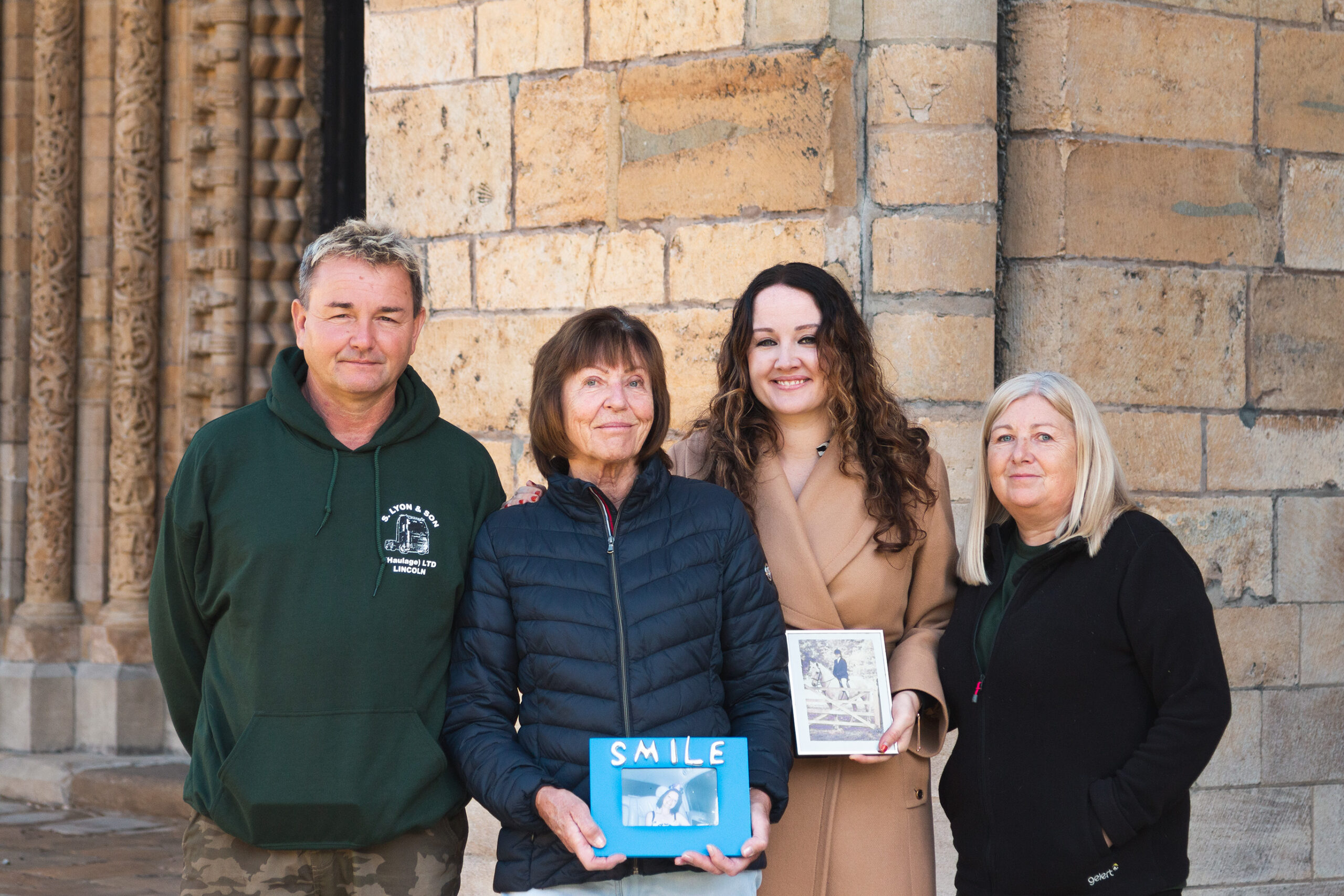 Members, of the Lyon family, together at Lincoln Cathedral, holding photographs of Sharon, who was cared for by the hospice before she passed away.