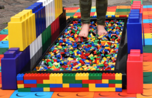 Person standing in a lane of LEGO to walk over, with colourful blocks all the way around