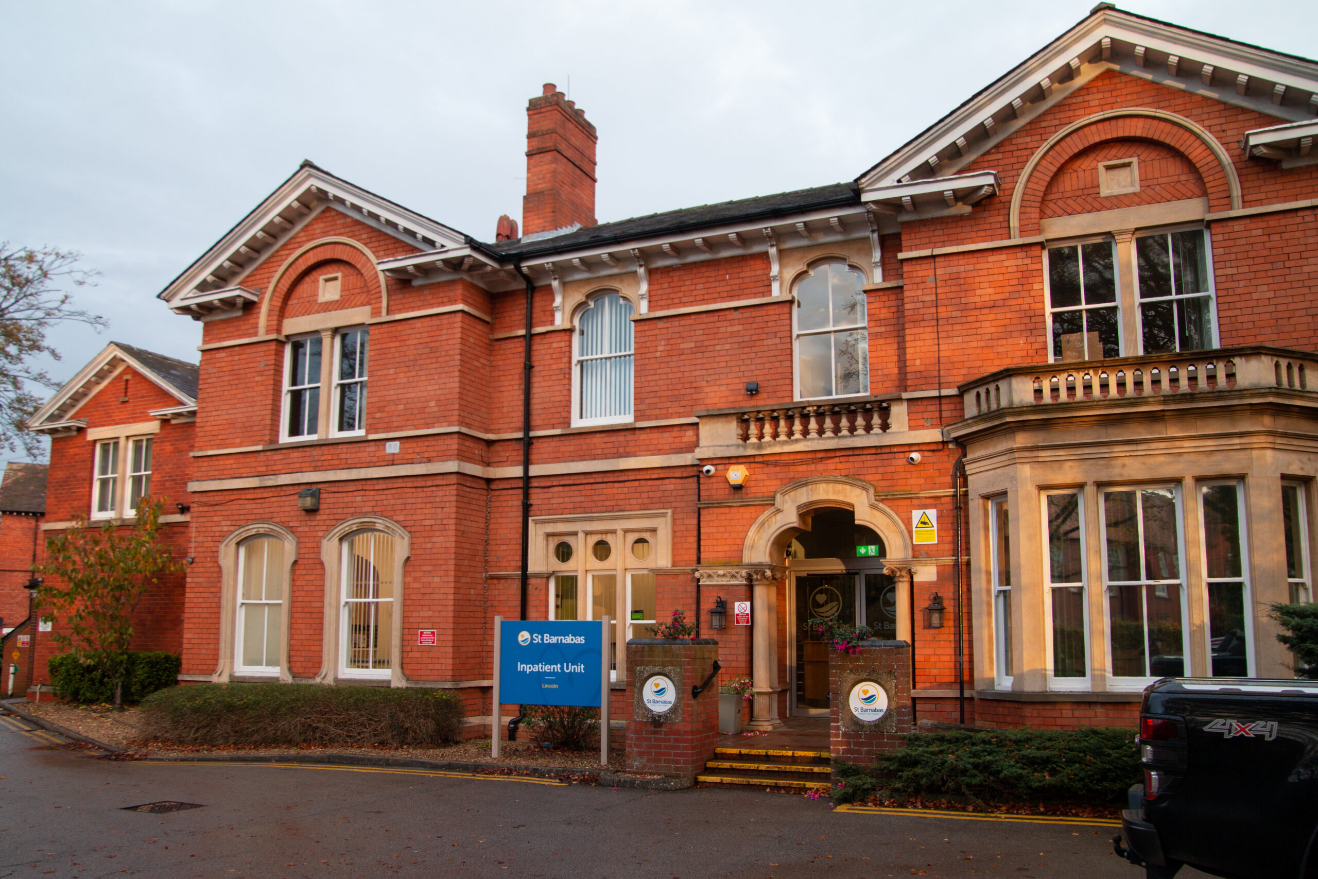 Red brick building with blue signage - the Inpatient Unit in Lincoln by St Barnabas Hospice.