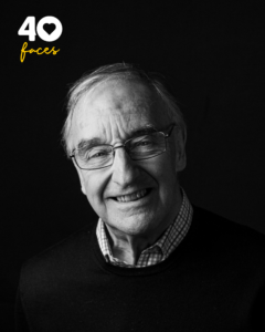 A man, Neil Paulger, who is a former staff member at St Barnabas Hospice, photographed in black and white, against a black backdrop