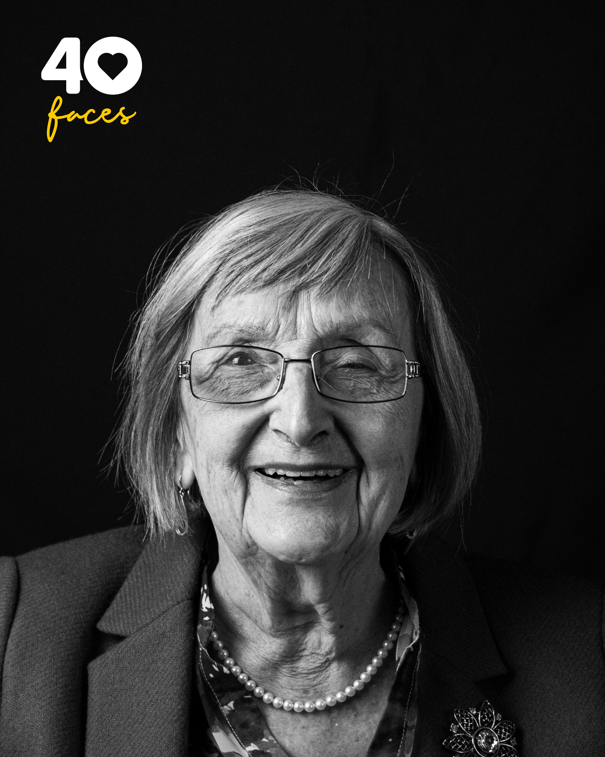 A lady, Sheila Briggs, who is one of the founders of St Barnabas Hospice, photographed in black and white, against a black backdrop