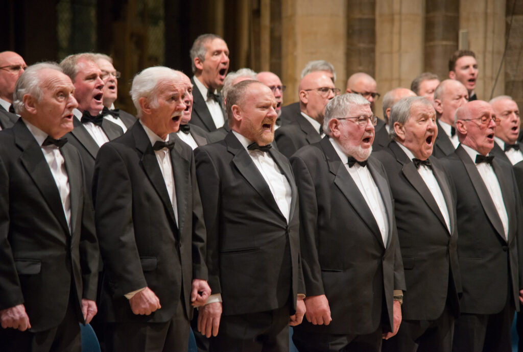 Men wearing tuxedo jackets singing
