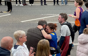 Woman in blue top hugging man during Manchester Marathon