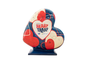 A Heart-shaped sculpture, painted in red, cream and white. This sculpture is part of the St Barnabas HeART Trail.