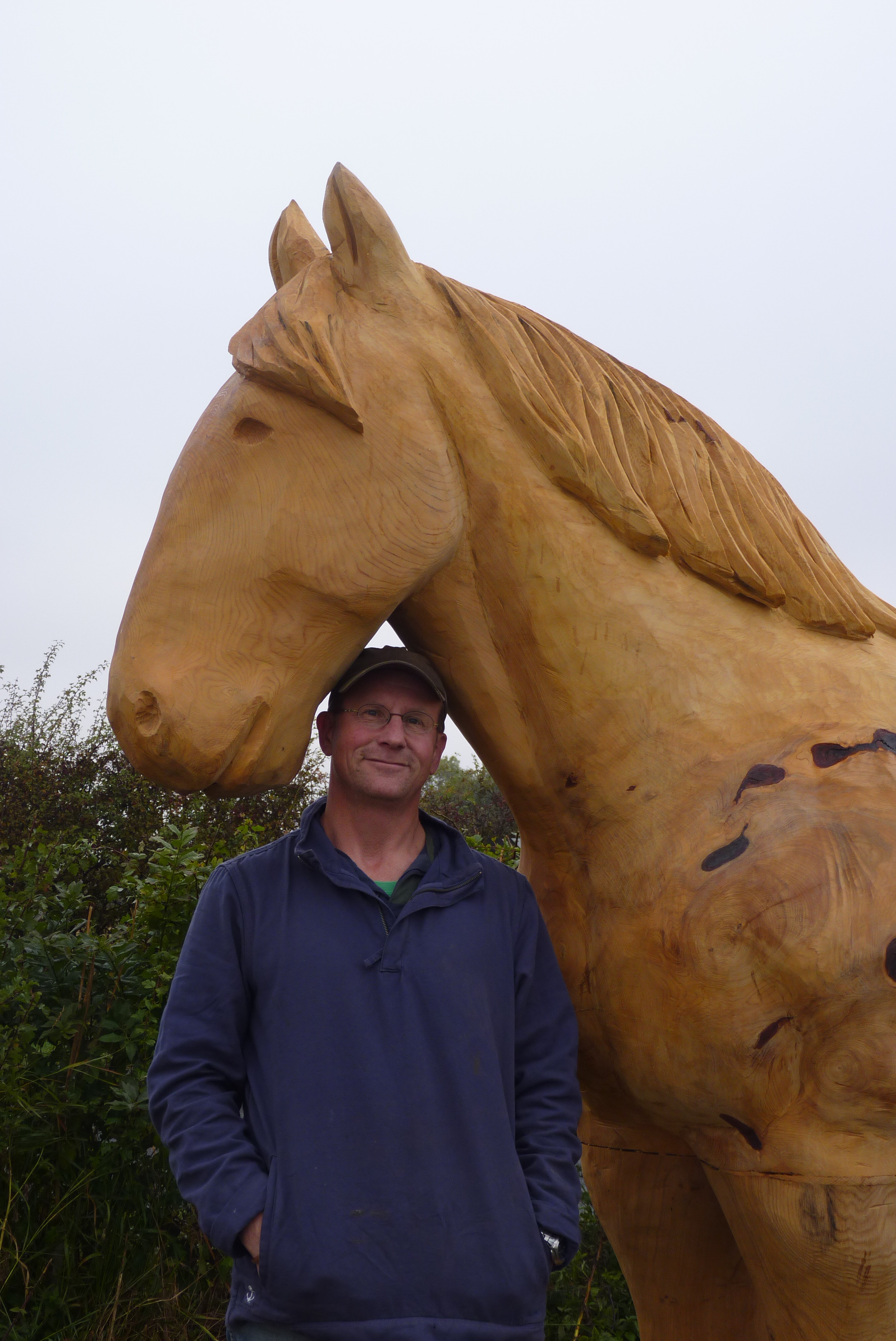 Nigel Sardeson, one of the Artists for the St Barnabas HeART Trail. Man with dark coloured top standing with life-sized sculpture of horse.