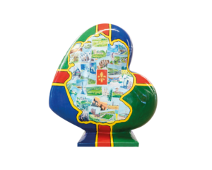 A Heart-shaped sculpture, painted with the Lincolnshire flag, featuring a map of Lincolnshire in the middle, with numerous postcard like illustrations depicting areas across Lincolnshire. This sculpture is part of the St Barnabas HeART Trail.