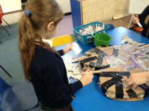Young child painting heart shaped artwork.