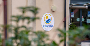 White round sign with St Barnabas logo on exterior wall at Grantham Wellbeing Centre
