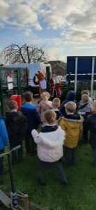 Rudy the reindeer waving to school children