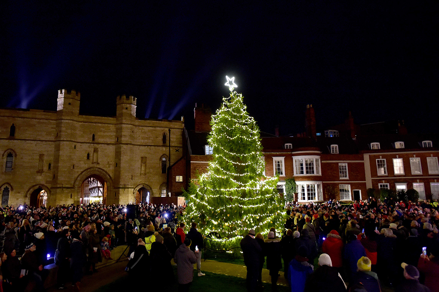 Tree of Life outside Lincoln Cathedral illuminated and surrounded by supporters