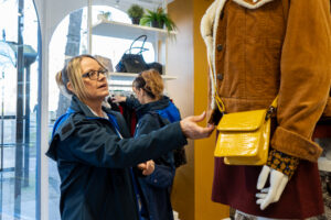 St Barnabas nurse touching jacket on charity shop mannequin 