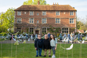 Warwick Davis and children stood in front of the Feathers from Above display and Aubourn Hall
