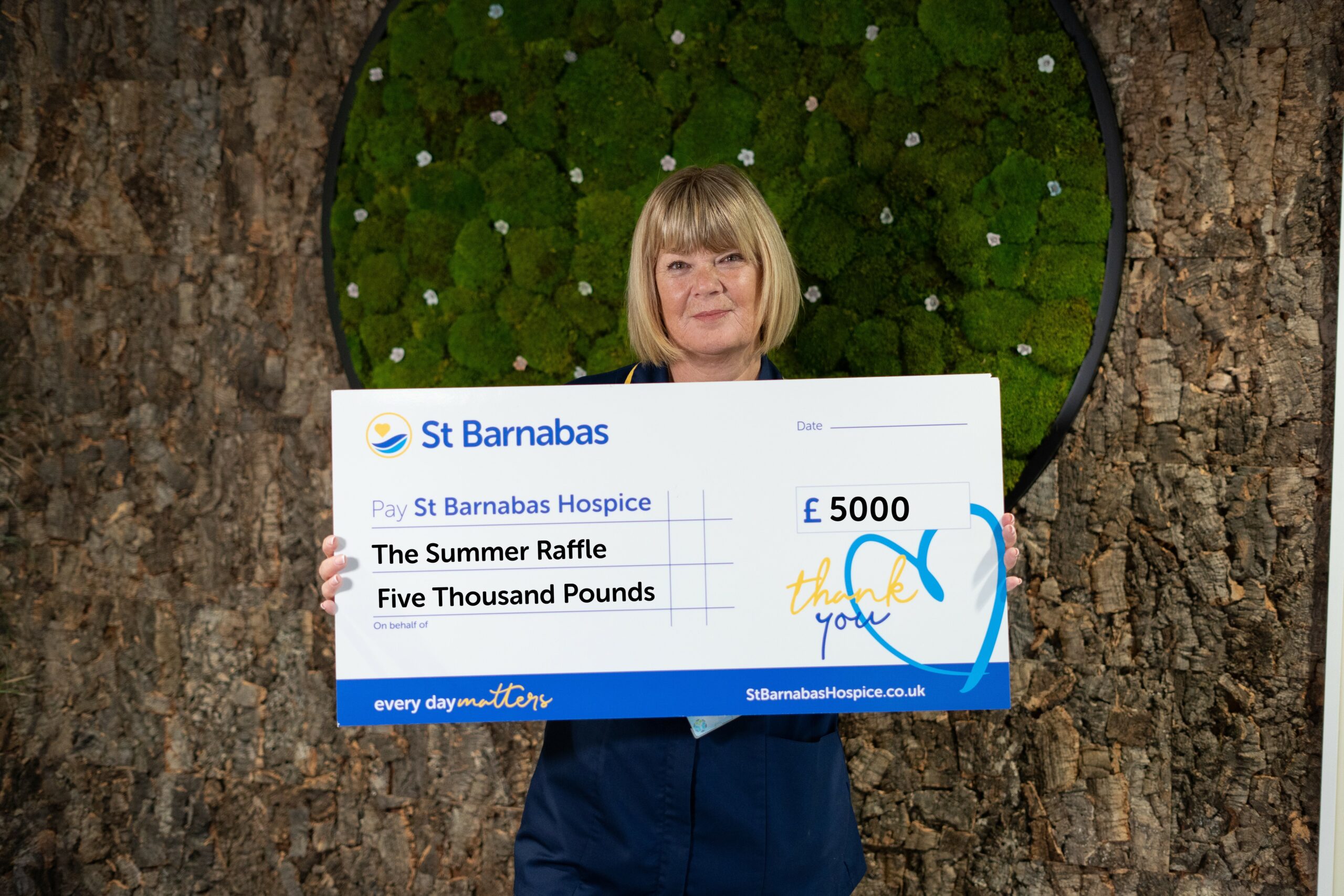 St Barnabas Nurse holding large cheque