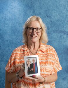 Ann Gregory holding photograph of her and her husband.  