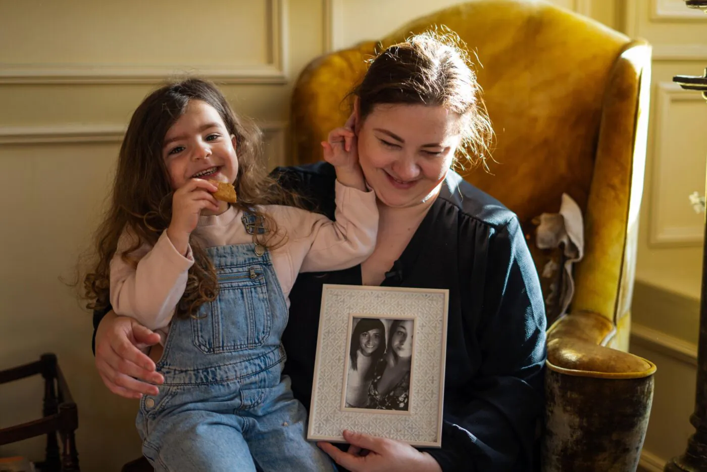 Rebeca with her daughter holding a photo of her sister